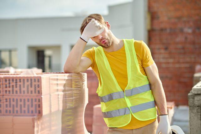 Tired worker touching face at construction site lavoro operaio cantiere caldo estate muratore